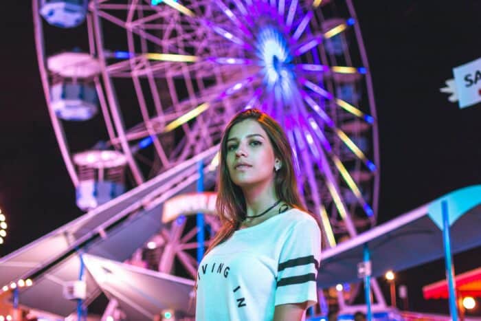 A Female Influencer With Long Dark Hair Stood In Front Of The Coachella Ferris Wheel